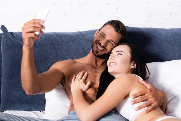 Happy Young Couple Taking Selfie While Lying Bed — Stock Photo, Image