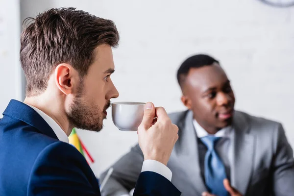 Tolk Drinken Koffie Buurt Van Afrikaans Amerikaans Zakenpartner Wazig Achtergrond — Stockfoto