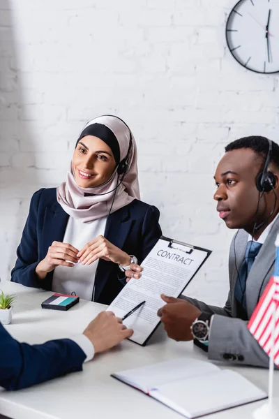 Arabscy Afrykańscy Amerykańscy Partnerzy Biznesowi Zestawach Słuchawkowych Pobliżu Tłumacza Wskazującego — Zdjęcie stockowe