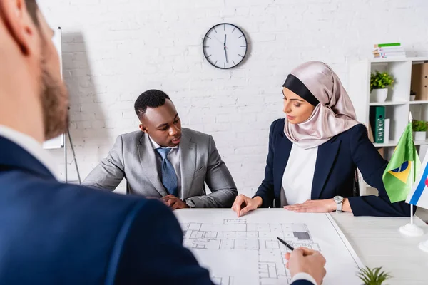 Multicultural Business Partners Talking Meeting Blueprint Interpreter Blurred Foreground — Stock Photo, Image
