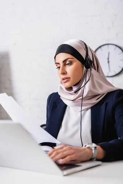 Arabian Translator Headset Working Documents Typing Laptop Blurred Foreground — Stock Photo, Image