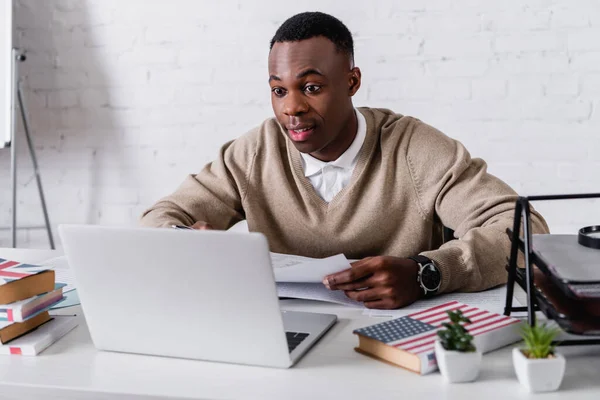 Amazed African American Translator Working Laptop Dictionaries Blurred Foreground — Stock Photo, Image