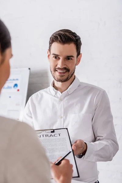 Zakenvrouw Ondertekening Contract Buurt Van Gelukkig Zakenpartner Wazig Voorgrond — Stockfoto