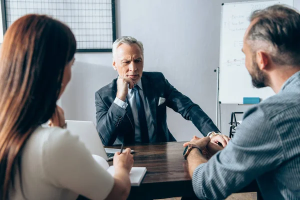 Pensive Investor Looking Business Partners Blurred Foreground Notebook Laptop Table — Stock Photo, Image