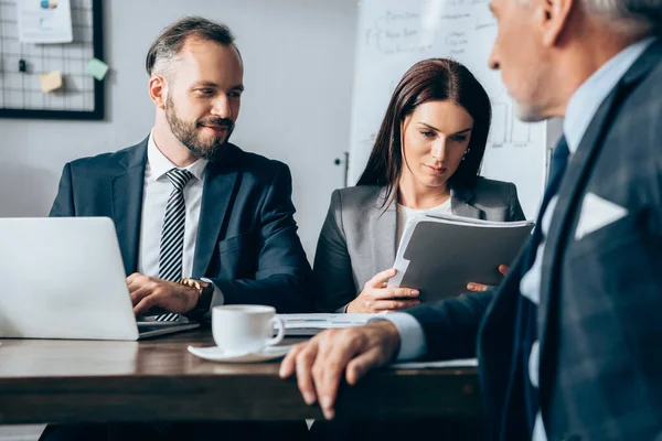 Hombre Negocios Sonriente Con Portátil Sentado Cerca Colega Con Carpeta — Foto de Stock