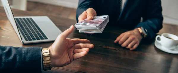 Cropped View Investor Giving Cash Businessman Laptop Coffee Blurred Background — Stock Photo, Image