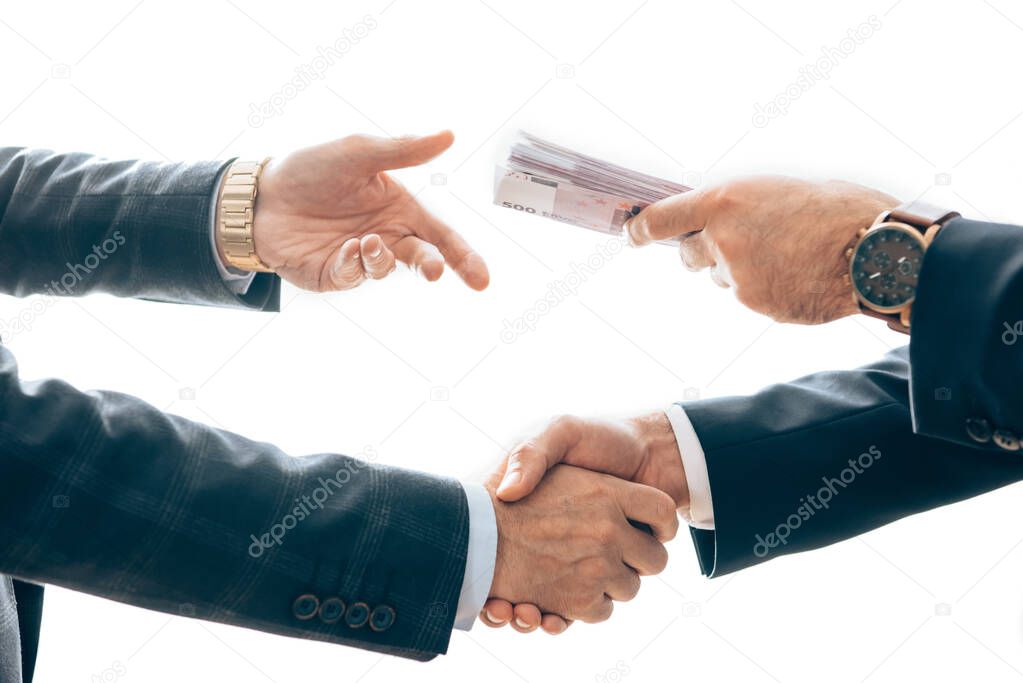 Cropped view of businessmen holding money and shaking hands isolated on white 