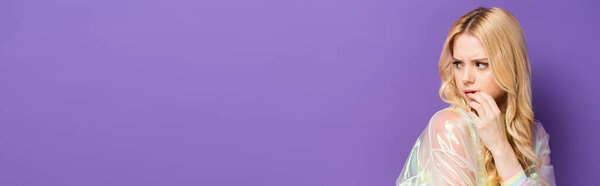 подчеркивается блондинка в красочном наряде глядя в сторону на фиолетовый фон, баннер