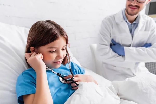 Menina Sorrindo Usando Estetoscópio Perto Sorrir Médico Fundo Borrado — Fotografia de Stock