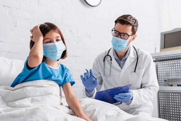 Doente Menina Tocando Cabeça Enquanto Sofre Dor Cabeça Perto Médico — Fotografia de Stock