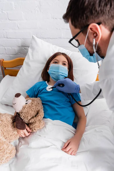 Sick Girl Medical Mask Lying Bed Teddy Bear While Doctor — Zdjęcie stockowe