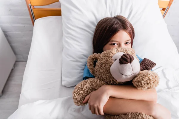 Top View Child Hugging Teddy Bear While Lying Bed Looking — Stock Photo, Image