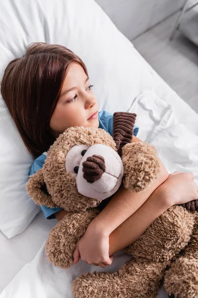 Upset Sick Girl Looking Away While Embracing Teddy Bear Hospital — 스톡 사진