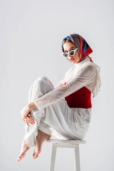 Stylish Woman Headscarf Sunglasses Sitting Stool While Posing Isolated White — Stock Photo, Image