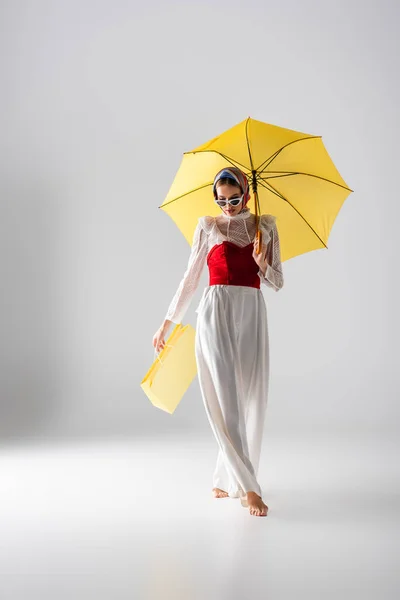 Türbanlı Güneş Gözlüklü Sarı Şemsiyeli Beyaz Pozlu Şık Bir Kadın — Stok fotoğraf