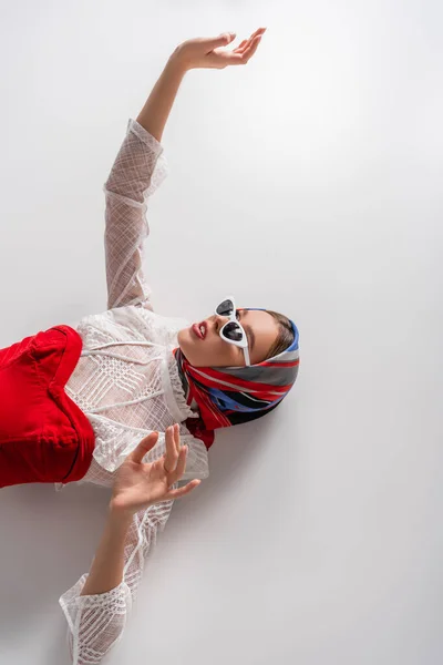 Top View Stylish Woman Headscarf Sunglasses Lying Outstretched Hand White — Stock Photo, Image