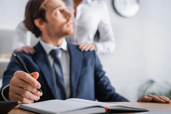 Hombre Negocios Sosteniendo Pluma Cerca Cuaderno Mientras Secretario Tocándose Los — Foto de Stock