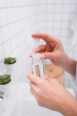 Banyoda elinde toner ve pamuk tutarken kısmi bir bakış açısı 