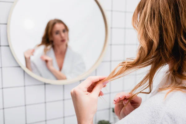 Frau Stellt Haare Spiegelnähe Auf Verschwommenem Hintergrund Ein — Stockfoto