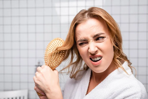 Mulher Descontente Roupão Banho Branco Escovando Cabelo Banheiro — Fotografia de Stock