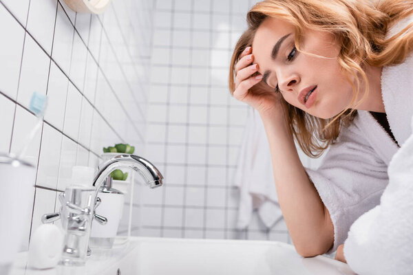 pregnant woman in bathrobe feeling nausea in bathroom 