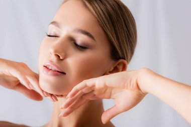 Şehvetli, genç bir kadın. Gözleri kapalı, beyaz yüzlere dokunuyor.