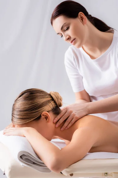 Massagista Desfocado Massageando Pescoço Cliente Deitado Mesa Massagem — Fotografia de Stock
