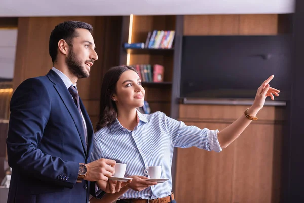 Sonriente Mujer Negocios Señalando Con Dedo Cerca Árabe Socio Negocios — Foto de Stock