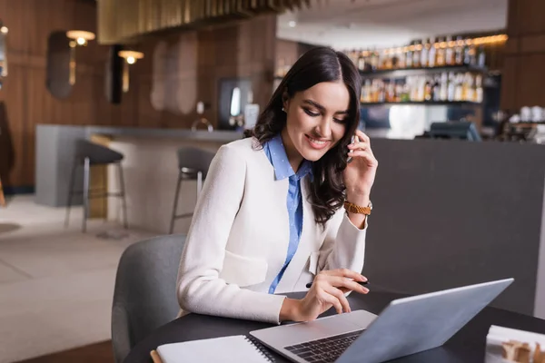 Smiling Freelancer Talking Smartphone While Using Laptop Restaurant — Stock Photo, Image