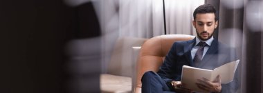 Arap işadamı restoran ve pankartta kağıt klasörüne bakıyor 