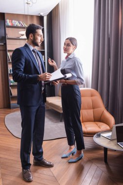 Restorandaki cihazların yanında panosu olan çok ırklı iş adamları 