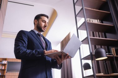 Restoranda dizüstü bilgisayar kullanan Arap işadamının düşük açılı görüntüsü 