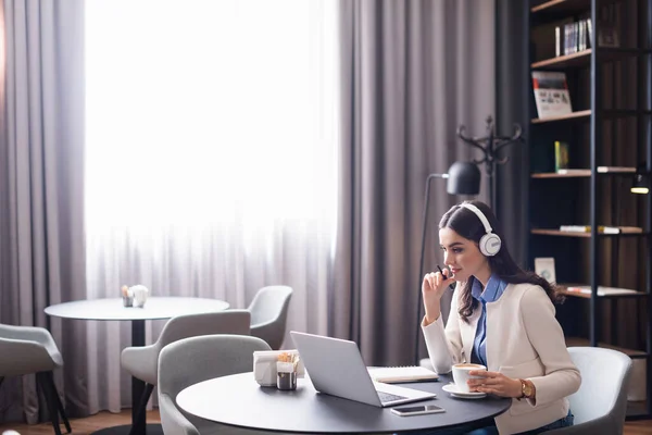 Freelancer Concentrado Auriculares Trabajando Cerca Laptop Taza Café Restaurante — Foto de Stock