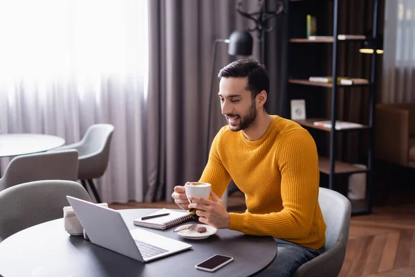 Excited Arabian Freelancer Laughing While Holding Cup Coffee Laptop Restaurant — Stock Photo, Image