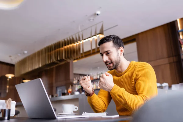 Emocionado Árabe Freelancer Mostrando Gesto Éxito Cerca Computadora Portátil Restaurante — Foto de Stock