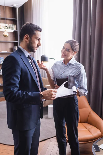 Smiling Businessman Notebook Looking Muslim Partner Clipboard Blurred Foreground Restaurant — Stock Photo, Image