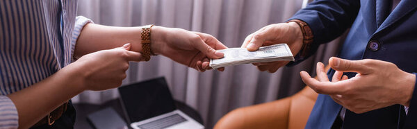 Cropped view of business partners holding dollar banknotes in restaurant, banner 