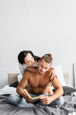 Gülümseyen kadın, seksi erkek arkadaşına sarılıyor. 