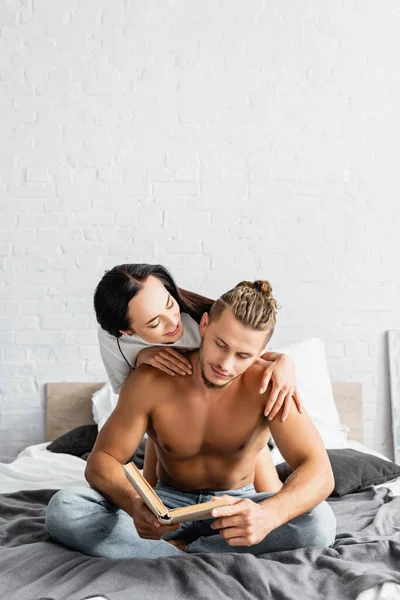 Smiling Woman Hugging Sexy Boyfriend Book Bed — Stock Photo, Image