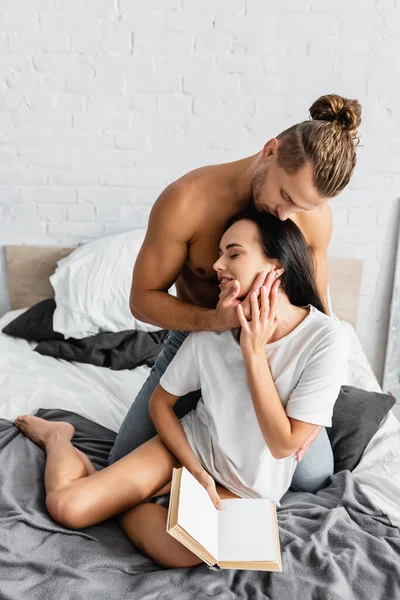 Sexy Man Kissing Smiling Girlfriend Book Bed — Stock Photo, Image