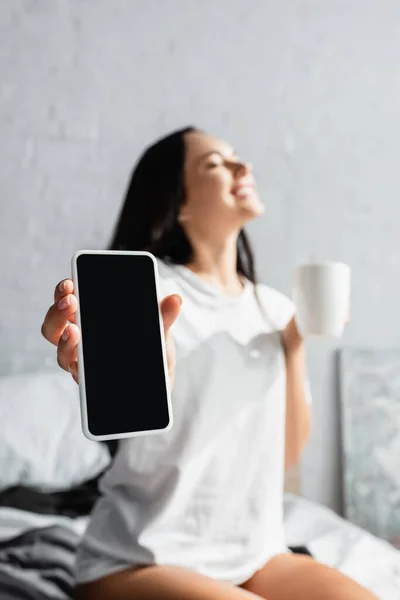 Smartphone Med Tom Skärm Handen Kvinna Med Kopp Sängen Suddig — Stockfoto