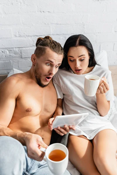 Amazed Couple Tea Using Digital Tablet Bed — Stock Photo, Image