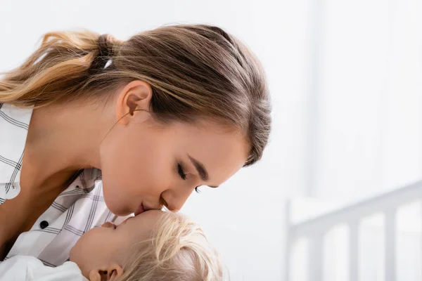 Mujer Joven Con Los Ojos Cerrados Besando Hijo Pequeño Casa — Foto de Stock