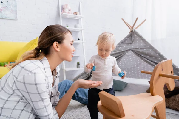 Young Mother Little Son Holding Wooden Cubes Rocking Horse — Stock Photo, Image