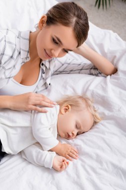 Mutlu annenin uyuyan oğluna dokunuşunun genel görüntüsü.