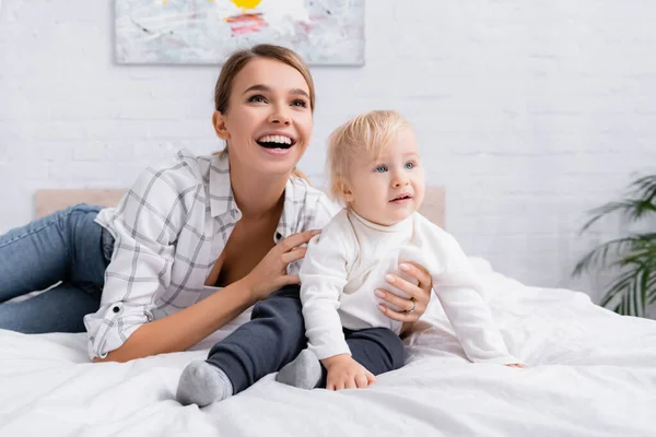 Excited Woman Hugging Little Son While Looking Away Bedroom — Stock Photo, Image