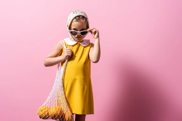 Menina Lenço Cabeça Ajustando Óculos Sol Enquanto Segurando Saco Corda — Fotografia de Stock