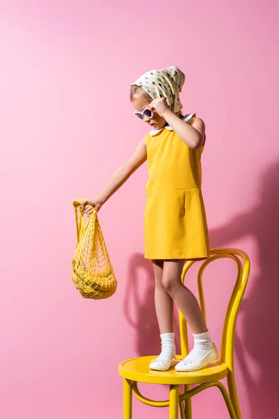 Child Headscarf Adjusting Sunglasses While Holding Reusable String Bag Bananas — Stock Photo, Image