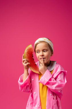 pensive girl in raincoat holding watermelon on crimson clipart