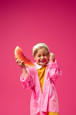 excited girl in raincoat holding watermelon on crimson clipart